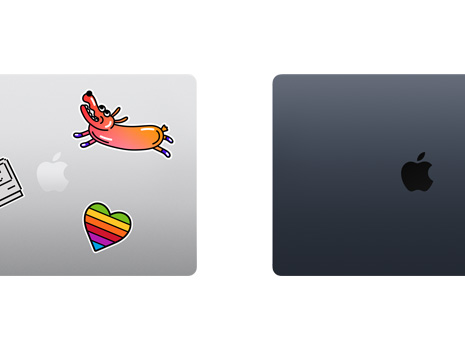 Vista de cima de dois notebooks Mac fechados, um com adesivos