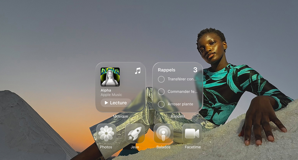 Affichage en Liquid Glass, montrant l’effet de réfraction des icônes transparentes des apps Musique, Rappels, Photos, Jeux, Balados et FaceTime sur le fond d’écran.