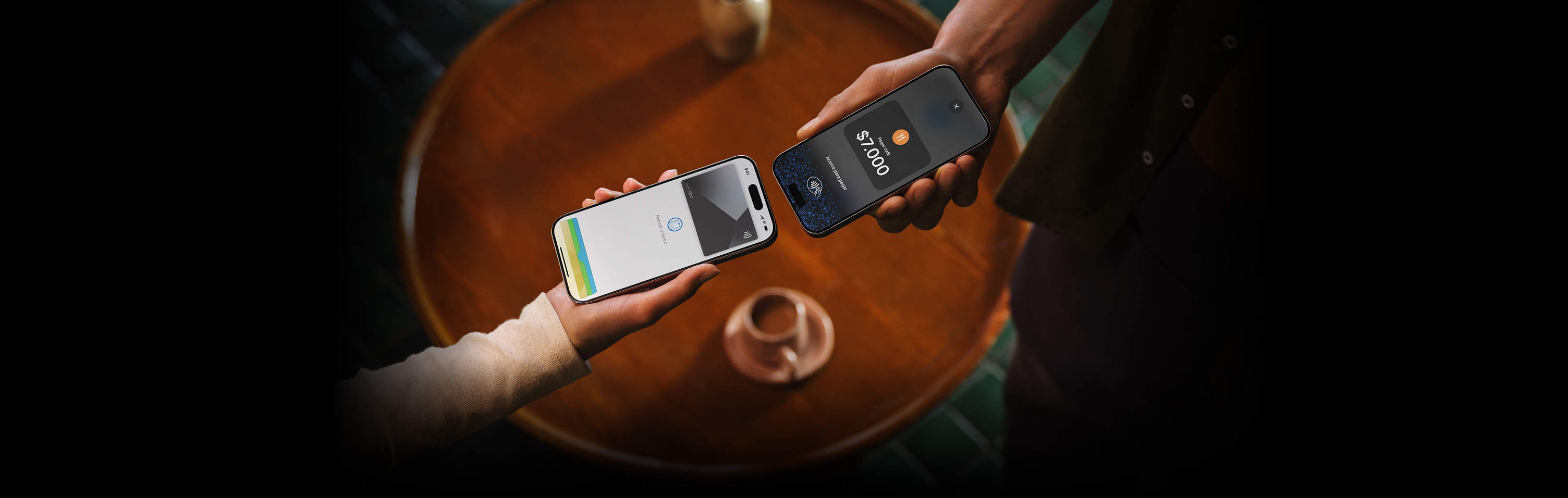 Imagen de dos personas que acercan sus dispositivos iPhone para realizar una transacción.