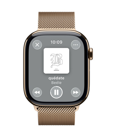 Apple Watch de titanio color oro con una correa estilo milanés, en cuya pantalla se ve la reproducción de una canción en Apple Music, así como el diseño translúcido de los controles en Liquid Glass