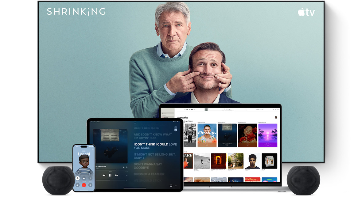 Large flat screen television showing two male characters from the Apple TV series shrinking. A MacBook Pro, an iPad, an iPhone, and a Midnight HomePod mini are arranged in front.