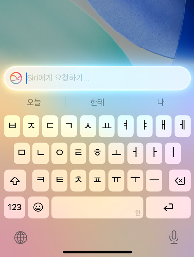 iPhone의 키보드 상단에 Ask Siri라고 적힌 텍스트 필드가 열려 있는 모습