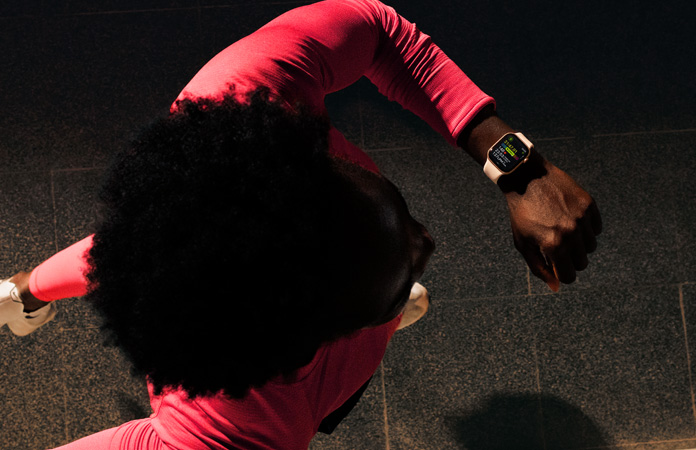 Una persona que corre consulta su progreso en la app Entrenamiento en un Apple Watch Series 11