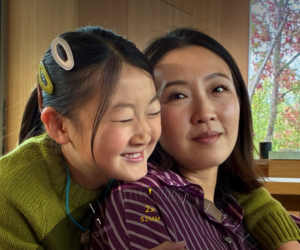 Tiek izmantota 2x telefoto funkcija, kadrā pietuvinot divus cilvēkus, kuri apkampjas