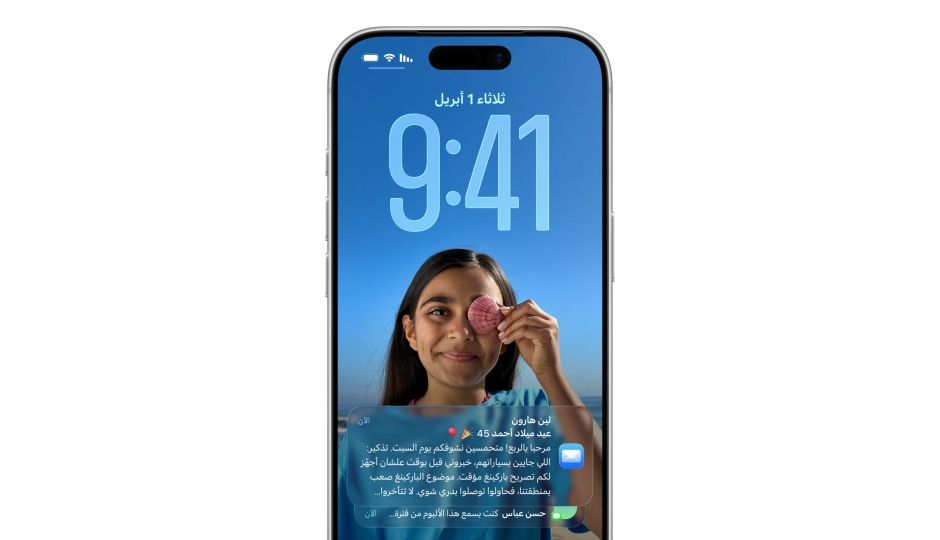 شاشة قفل iPhone مع صورة، أرقام تعرض الوقت بتصميم Liquid Glass، يظهر إشعاران في أسفل الشاشة