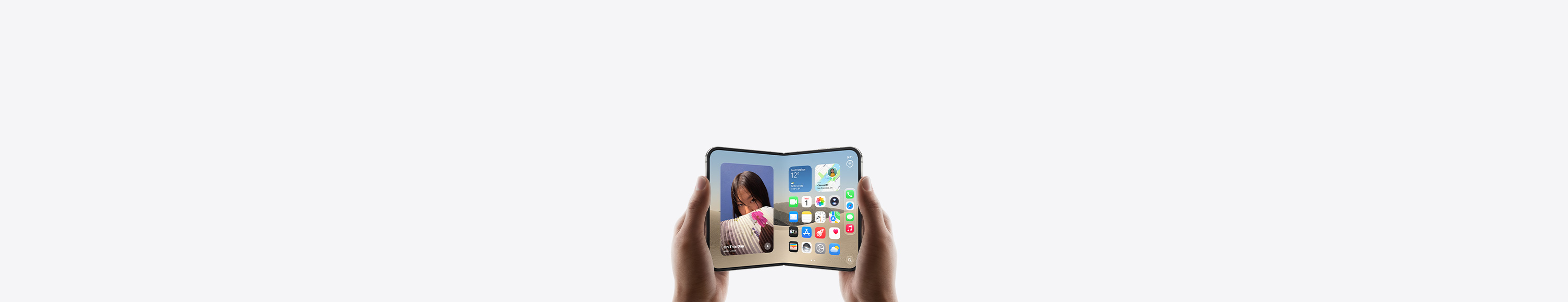 iPhone Duo, held by two hands in landscape orientation, unfolded, interior display features Home Screen