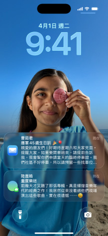 五款層疊的 iPhone 機型微微展開，每款機型彼此略微重疊。最左側的螢幕展示訊息 app 中設有背景的對話；左側第二個螢幕展示主畫面，其中包含色彩繽紛的 app 圖像；中間的機型展示鎖定畫面，其中包含照片、呈現時間的 Liquid Glass 數字設計，以及兩則顯示在螢幕底部的通知；右側第二款機型展示 Liquid Glass 設計的透明 app 圖像；最右側的機型展示 Liquid Glass 設計下的音樂播放器