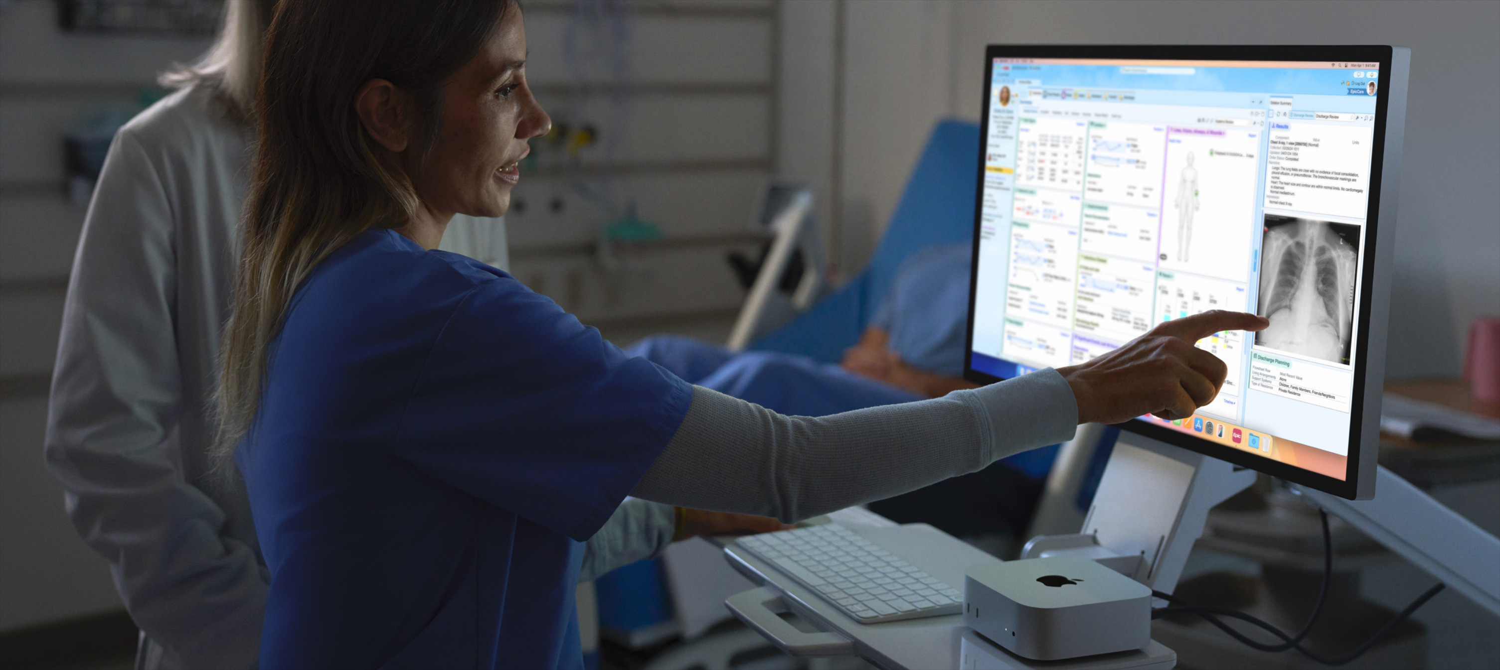 Image of a nurse pointing out patient's X-ray image on iMac.