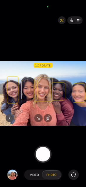Schermata di un iPhone 17 Pro che mostra la funzione Inquadratura automatica per le foto e come scattare un selfie di un gruppo, con i volti evidenziati