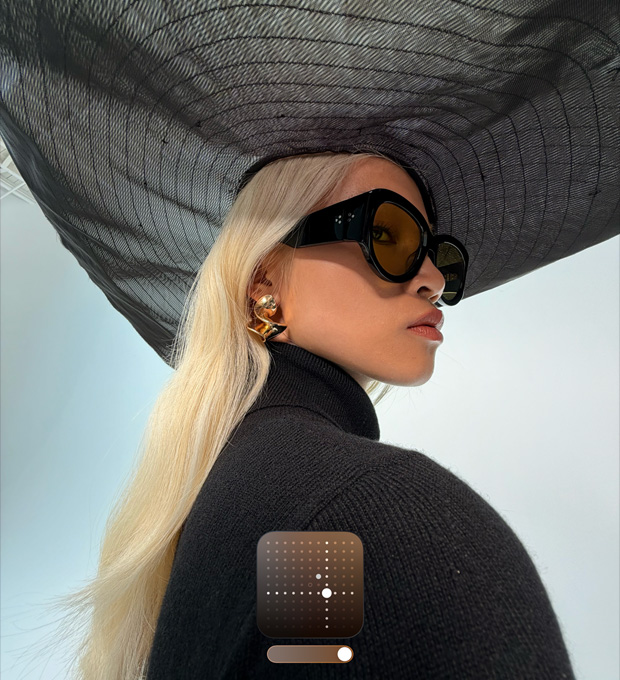 Ritratto di una donna con un cappello nero a falda larga a cui è stato applicato lo stile Luminoso, che migliora la luminosità delle foto scattate in condizioni di scarsa illuminazione o in modalità Notte