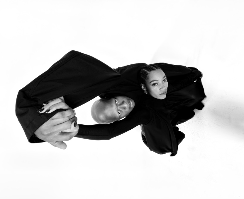 Foto in bianco e nero di due persone scattata con ampio angolo di campo, per mostrare le capacità dell’ultra-grandangolo di iPhone 17 Pro