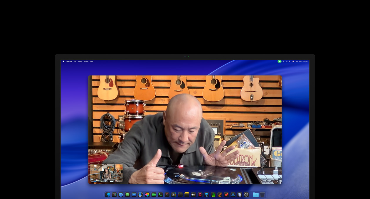 Durante una videollamada, una persona en una tienda de música mira de cerca un tocadiscos, y gracias a la cámara Center Stage, sigue en el centro del cuadro