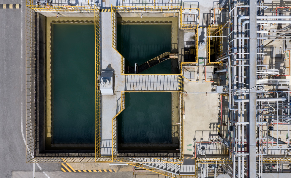 Aerial view of industrial water treatment tanks arranged in a grid pattern.